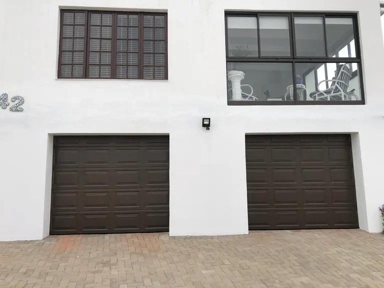 Two single brown panelled sectional garage doors