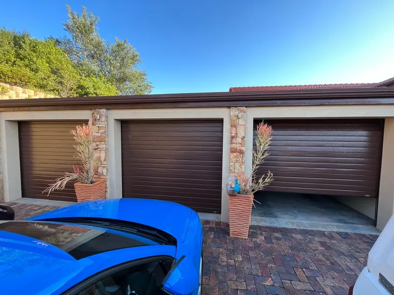 Three separate brown garage doors, one partly open
