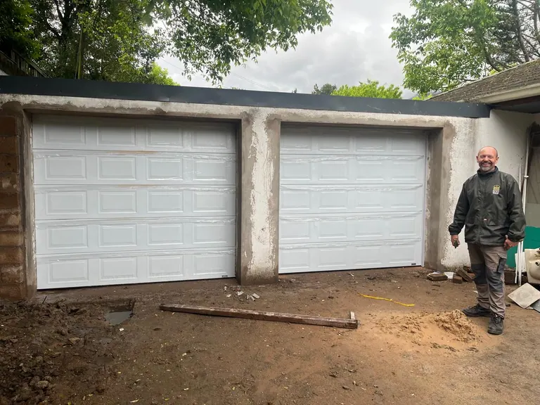 Two single white panelled sectional garage doors